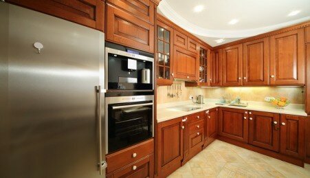 Light clean kitchen with wooden furniture, integrated oven